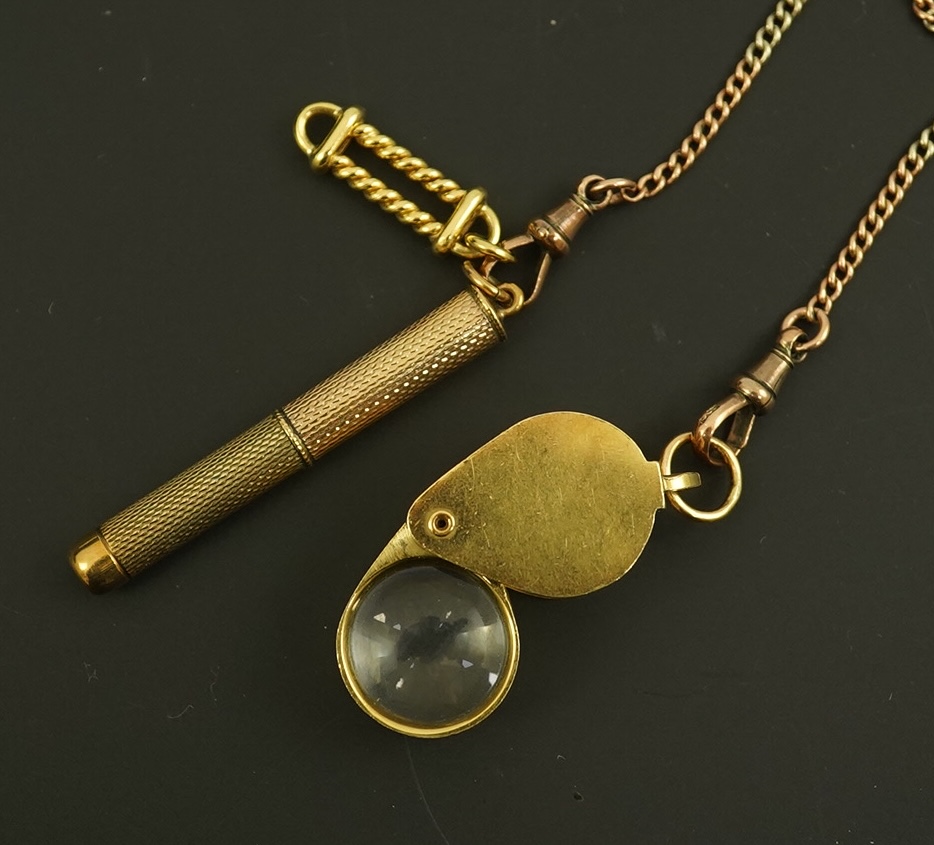 A modern 18ct gold mounted jeweller's loupe, 24mm and a 9ct gold cased propelling toothpick, both suspended from a two colour 9ct gold chain